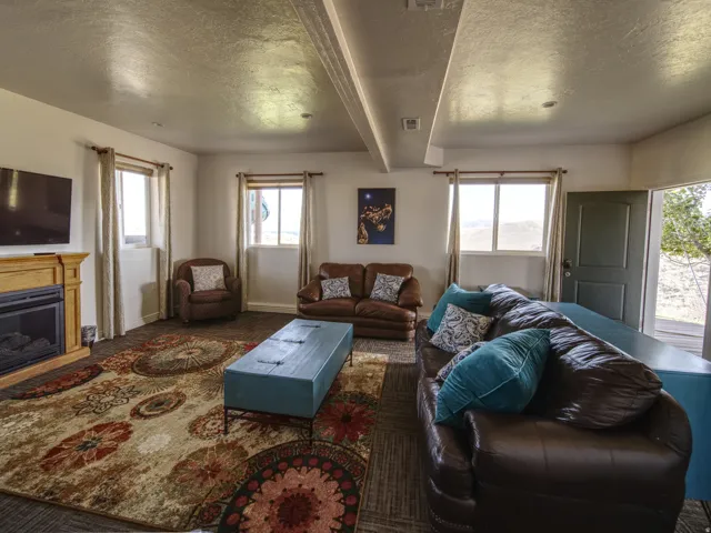 Spacious interior room featuring multiple windows, a light wood-finish fireplace, and an exterior door