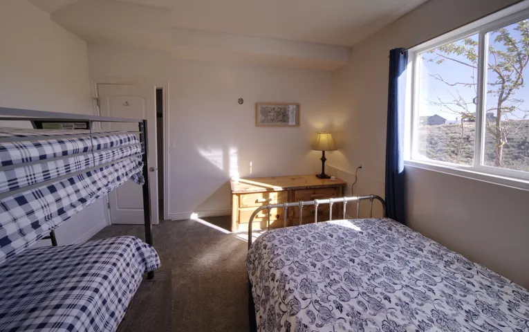 Room featuring an exterior window with a clear pane, light-colored walls, and a gray carpeted floor