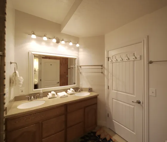 Double vanity with undermount sinks, a light-toned countertop, and wood-finish cabinetry