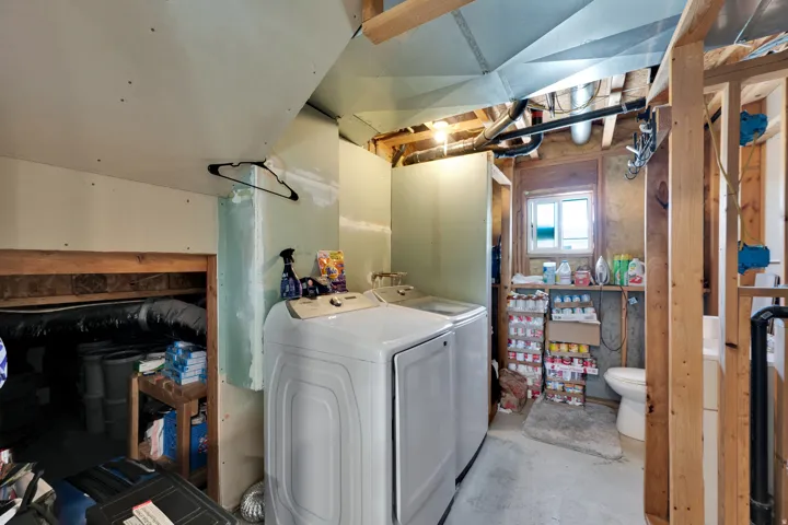Utility room featuring concrete flooring and exposed ceiling ductwork