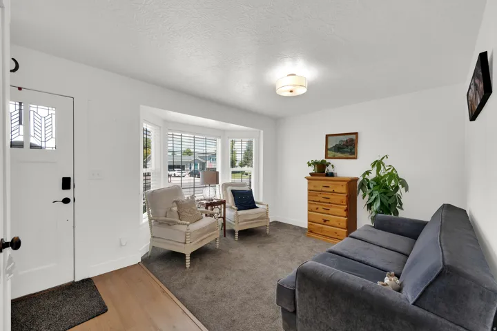 Living area with a prominent bay window featuring multiple panes and horizontal blinds