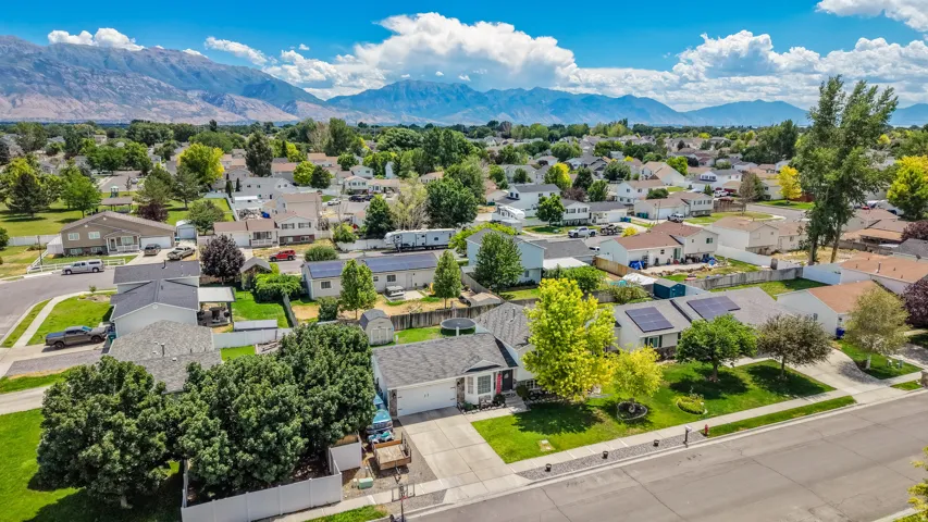 Residential neighborhood with established homes, mature trees, and mountain scenery