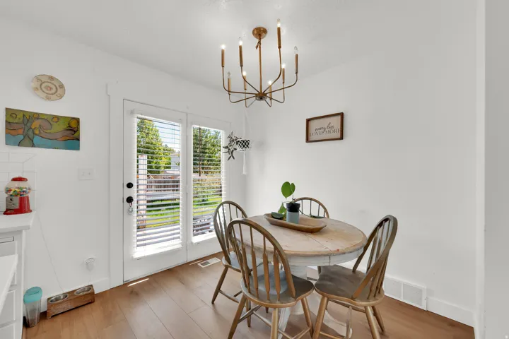 Dining area featuring wood-finish flooring and a contemporary chandelier