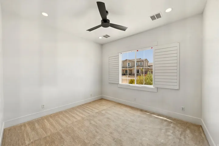 Room featuring carpet flooring, recessed lighting, a ceiling fan, and a window with plantation shutters