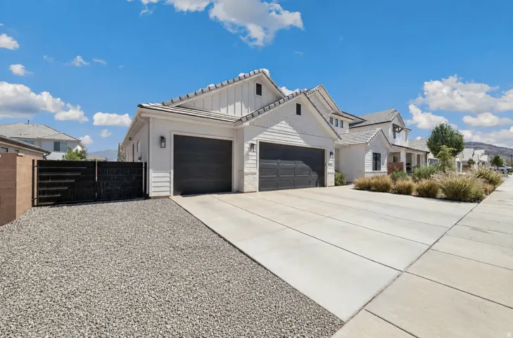 Modern two-car garage with dark panel doors and expansive concrete driveway