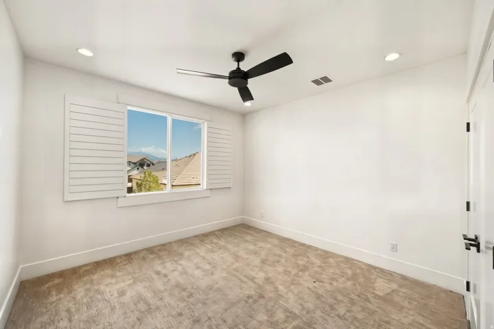 Room featuring carpeted flooring, a ceiling fan with black blades, and recessed lighting