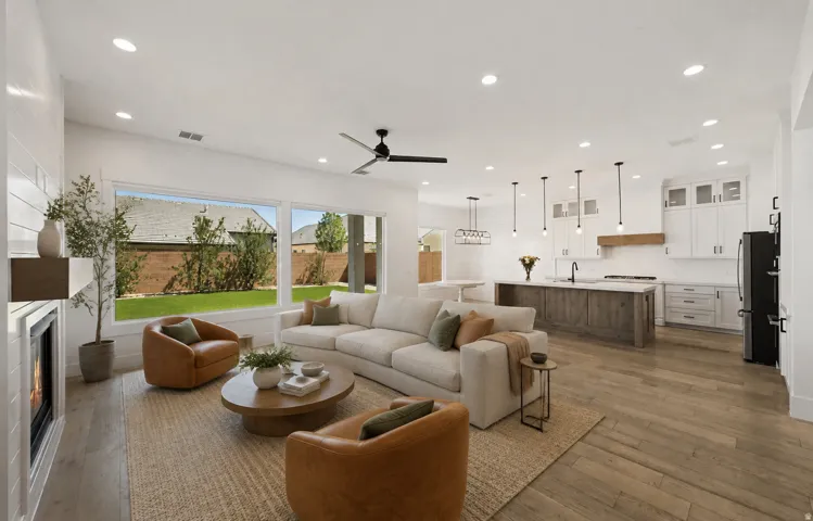 Open-concept living area featuring wood-finish flooring, recessed lighting, and a contemporary fireplace with shiplap detailing