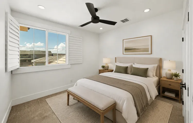 Bright bedroom featuring a large window with white plantation shutters, a ceiling fan with integrated lighting, recessed lighting, and neutral carpeting