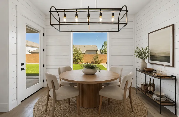 Dining area featuring a contemporary chandelier, shiplap wall finishes, and wood-finish flooring