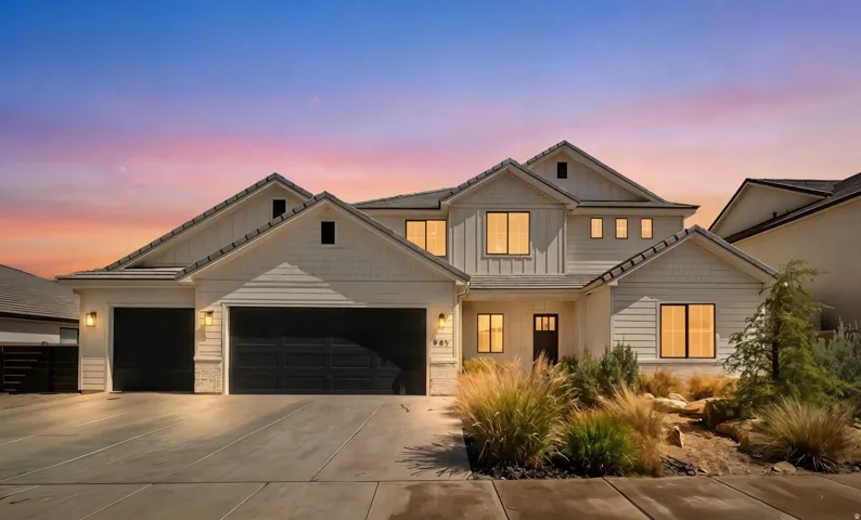 Contemporary two-story residence featuring white siding, a multi-gabled roofline, and a three-car garage with dark doors