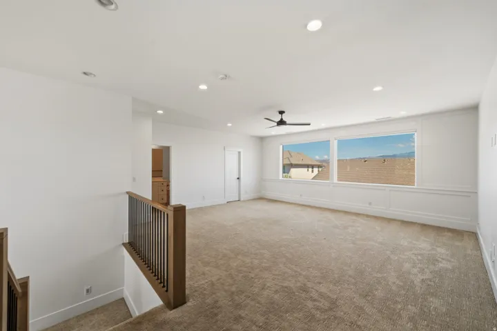 Spacious upper-level room featuring large windows with mountain scenery, recessed lighting, and a ceiling fan