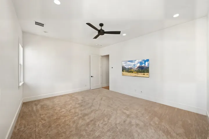 Expansive room featuring neutral carpet flooring, crisp white walls, and a recessed lighting package