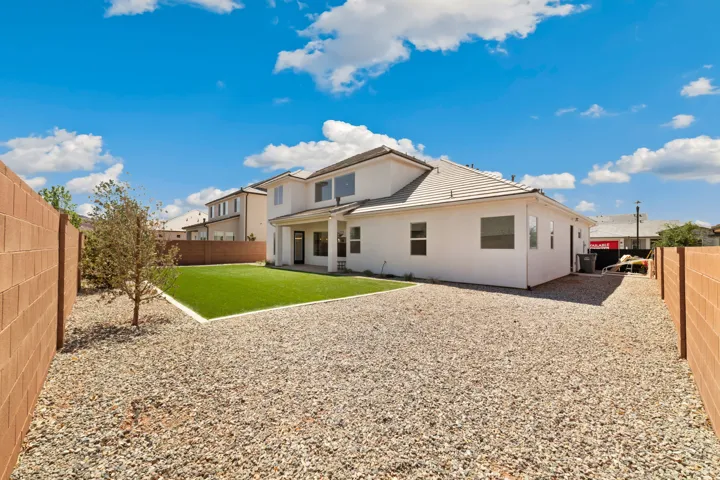 Rear exterior showcasing a neutral stucco finish and a tiled roof