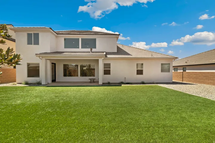 Spacious backyard featuring an extensive artificial turf lawn
