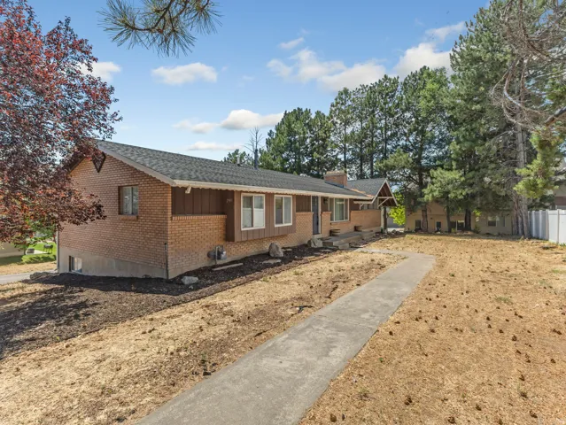 Brick and siding exterior featuring a covered entry and a long concrete walkway