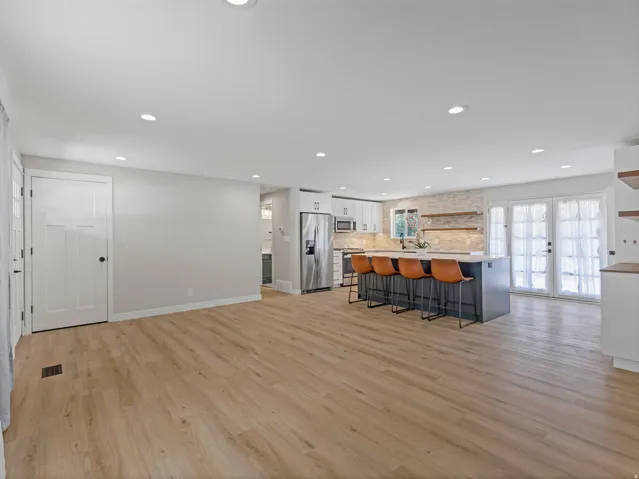Bright kitchen and living area featuring wood-finish flooring