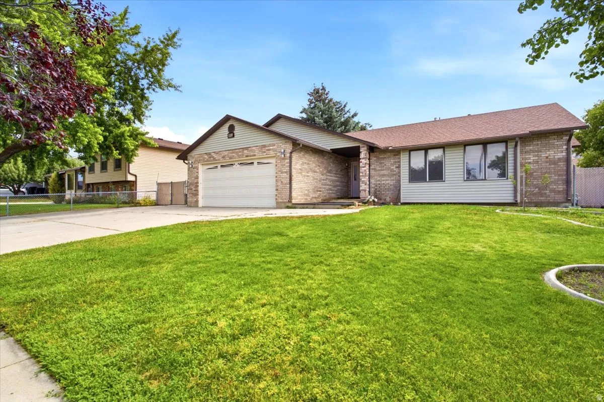 Single-story residence featuring a brick and siding exterior, an attached garage, and a concrete driveway