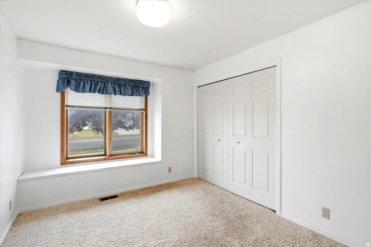 Bright room featuring a wide window with a built-in sill and a multi-pane bi-fold closet