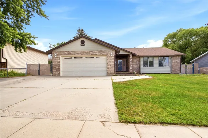 Ranch-style residence featuring a combination of brick and siding, a two-car garage, and a concrete driveway