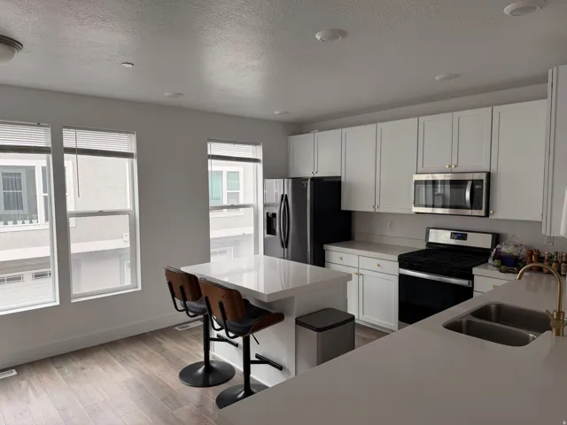 Contemporary kitchen featuring white cabinetry and light countertops