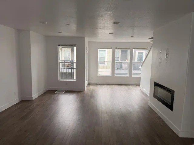 Spacious living area featuring wood-finish flooring, recessed lighting, and white walls