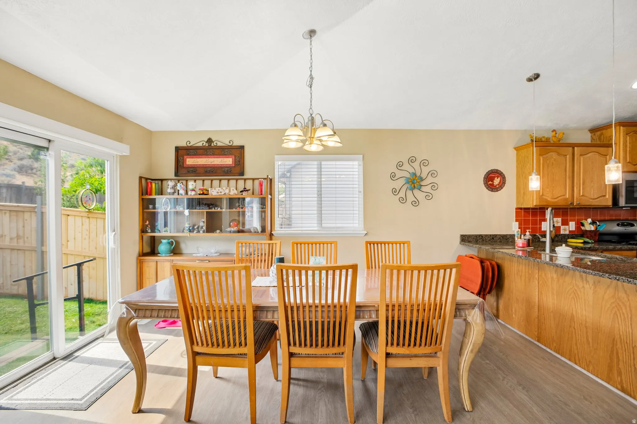 Dining area with vaulted ceiling and wood-finish flooring