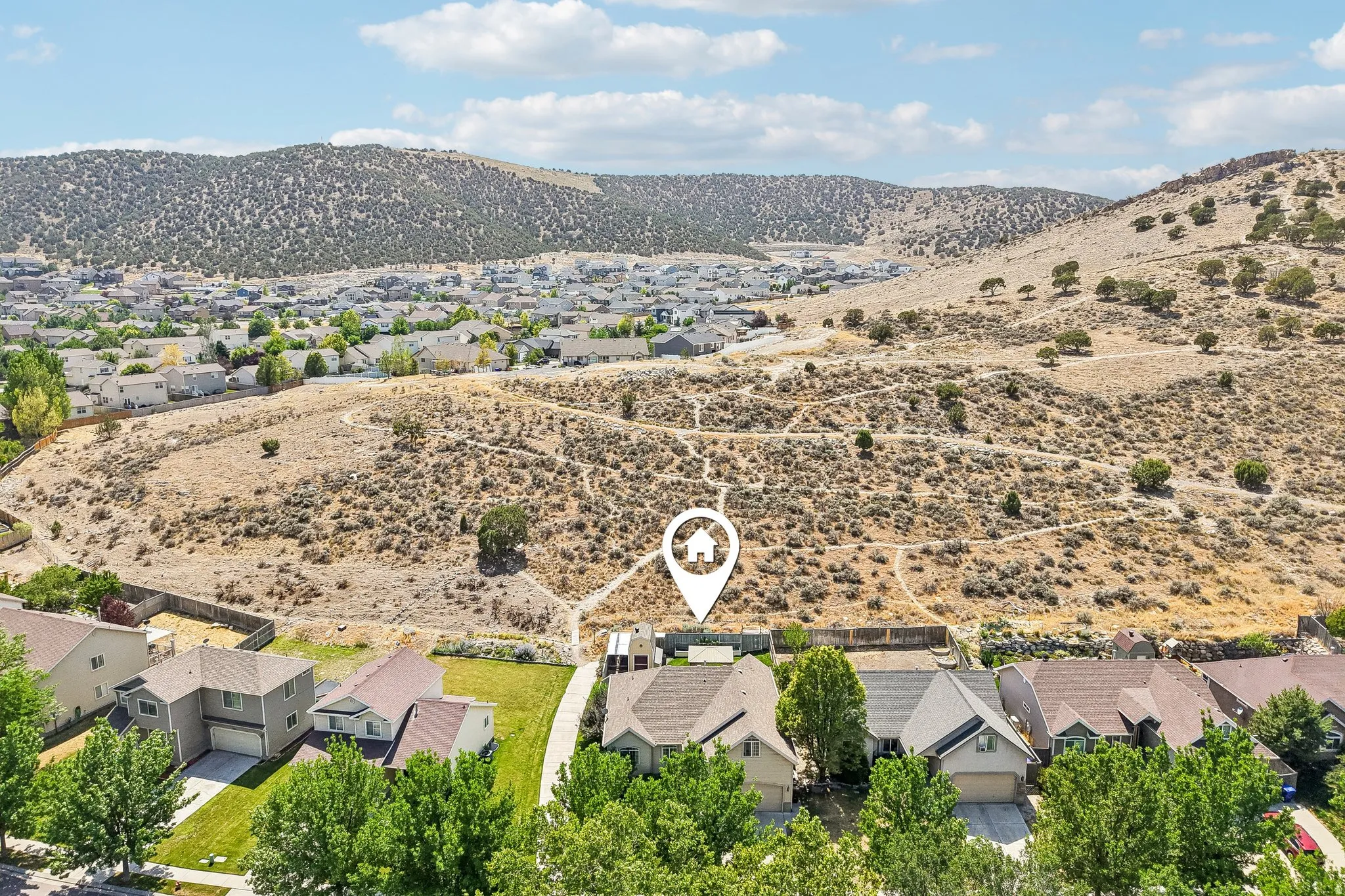 Community setting with a backdrop of arid hills and distant residential development