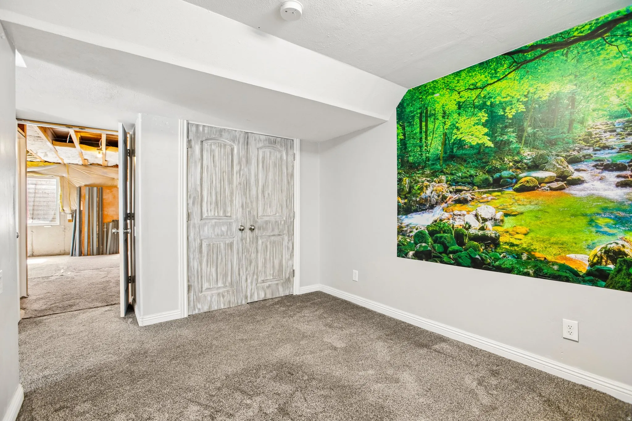 Room featuring light gray walls, gray carpeting, and white baseboards