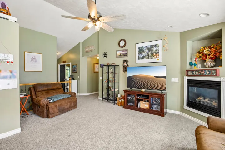 Living area with vaulted ceilings, recessed lighting, and a ceiling fan