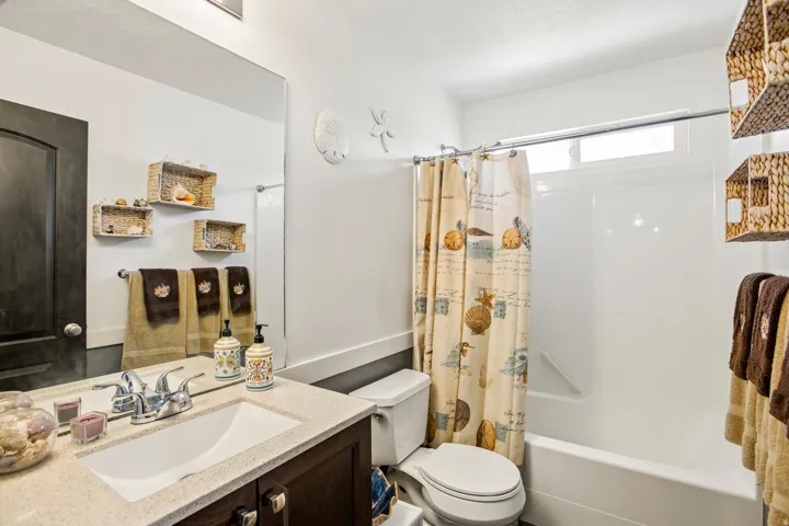 Bathroom featuring a vanity with an integrated sink, polished chrome faucet, and speckled countertop