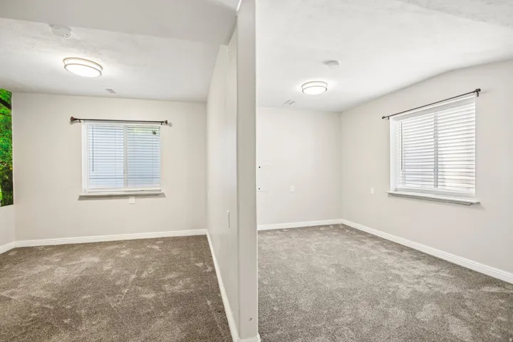 Neutral wall color with white trim and grey carpeting