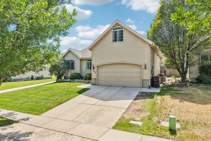 Exterior featuring light-colored siding, a two-car garage, an arched window, and a concrete driveway