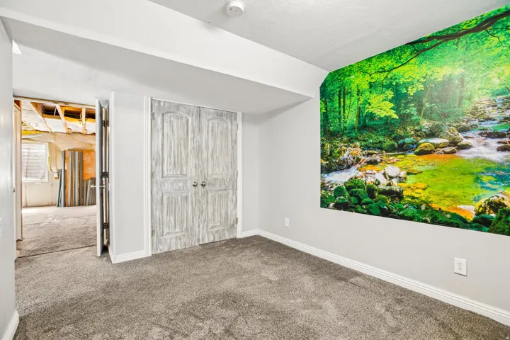 Room featuring light gray walls, gray carpeting, and white baseboards