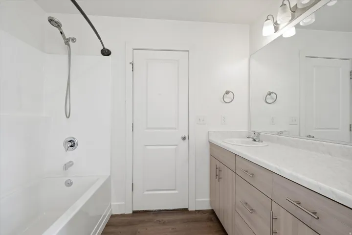 Bathroom featuring a single vanity with wood-finish cabinetry, a white countertop, and an integrated sink