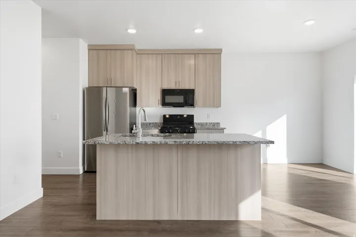 Modern kitchen with light wood-finish cabinetry and stainless steel appliances