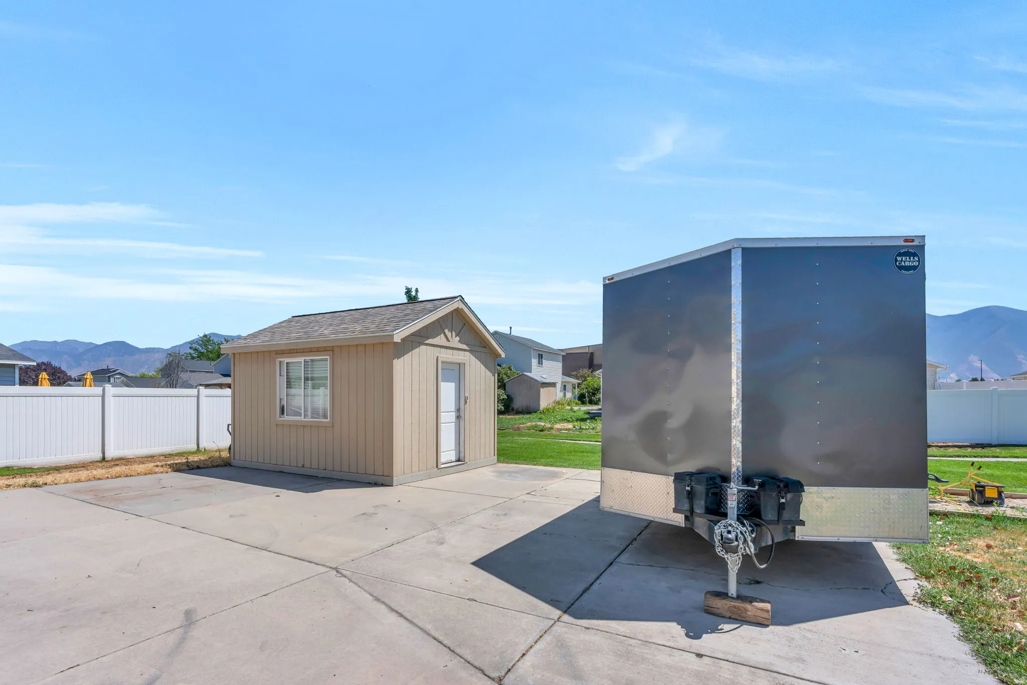 Concrete pad featuring a detached storage shed with a window and a side entry door