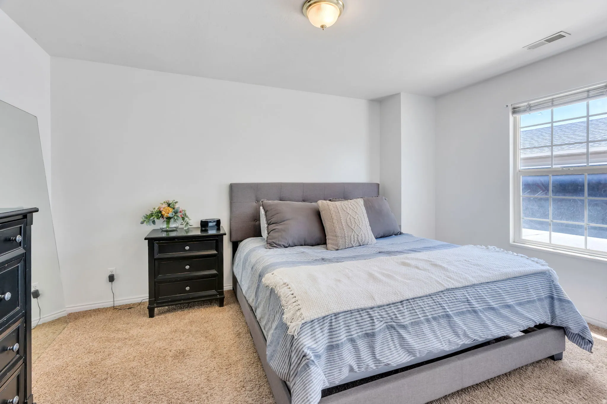 Bedroom featuring neutral white walls and carpeted flooring