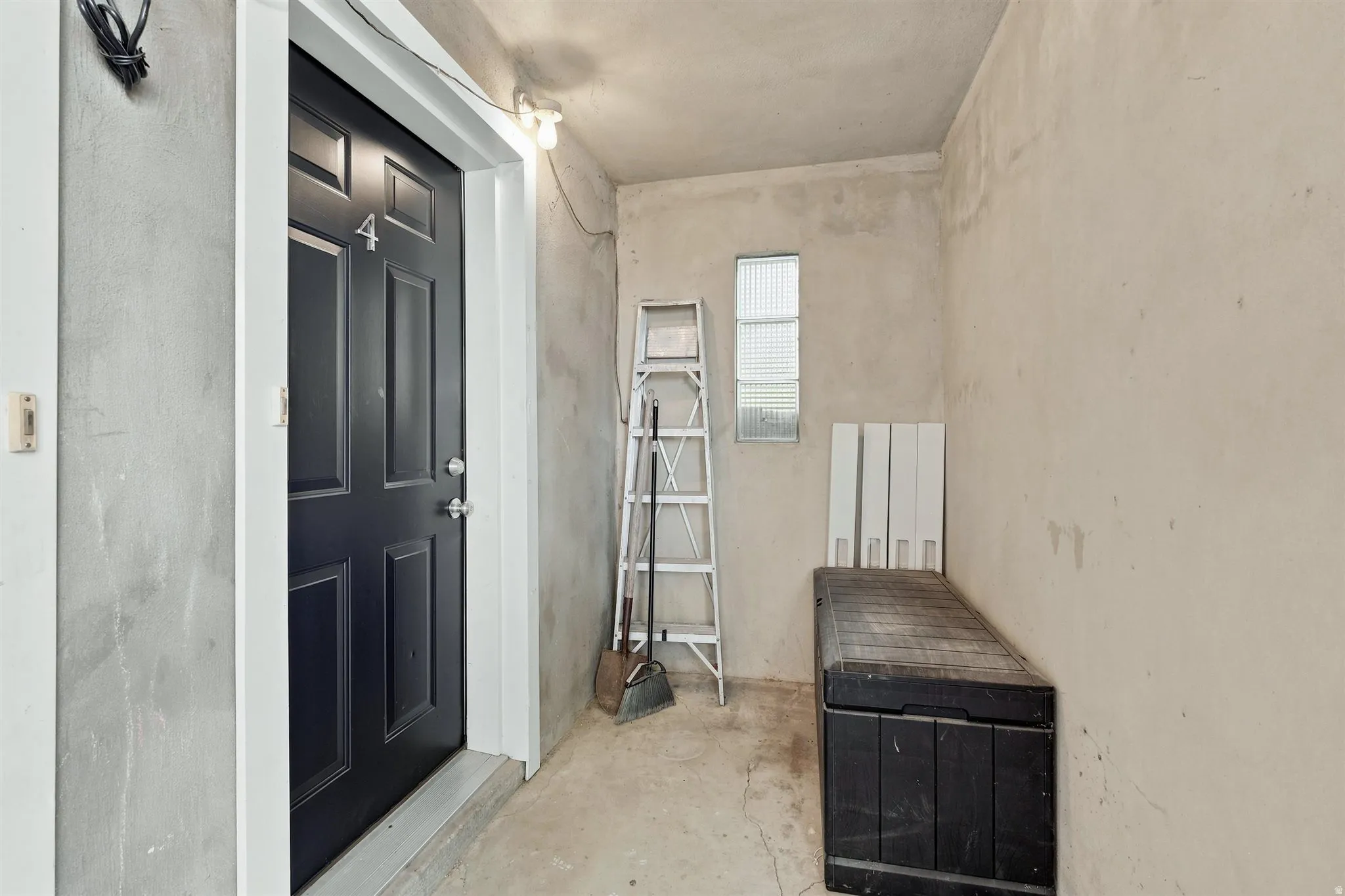 Black paneled entry door with white trim, featuring a number "4" and contemporary hardware