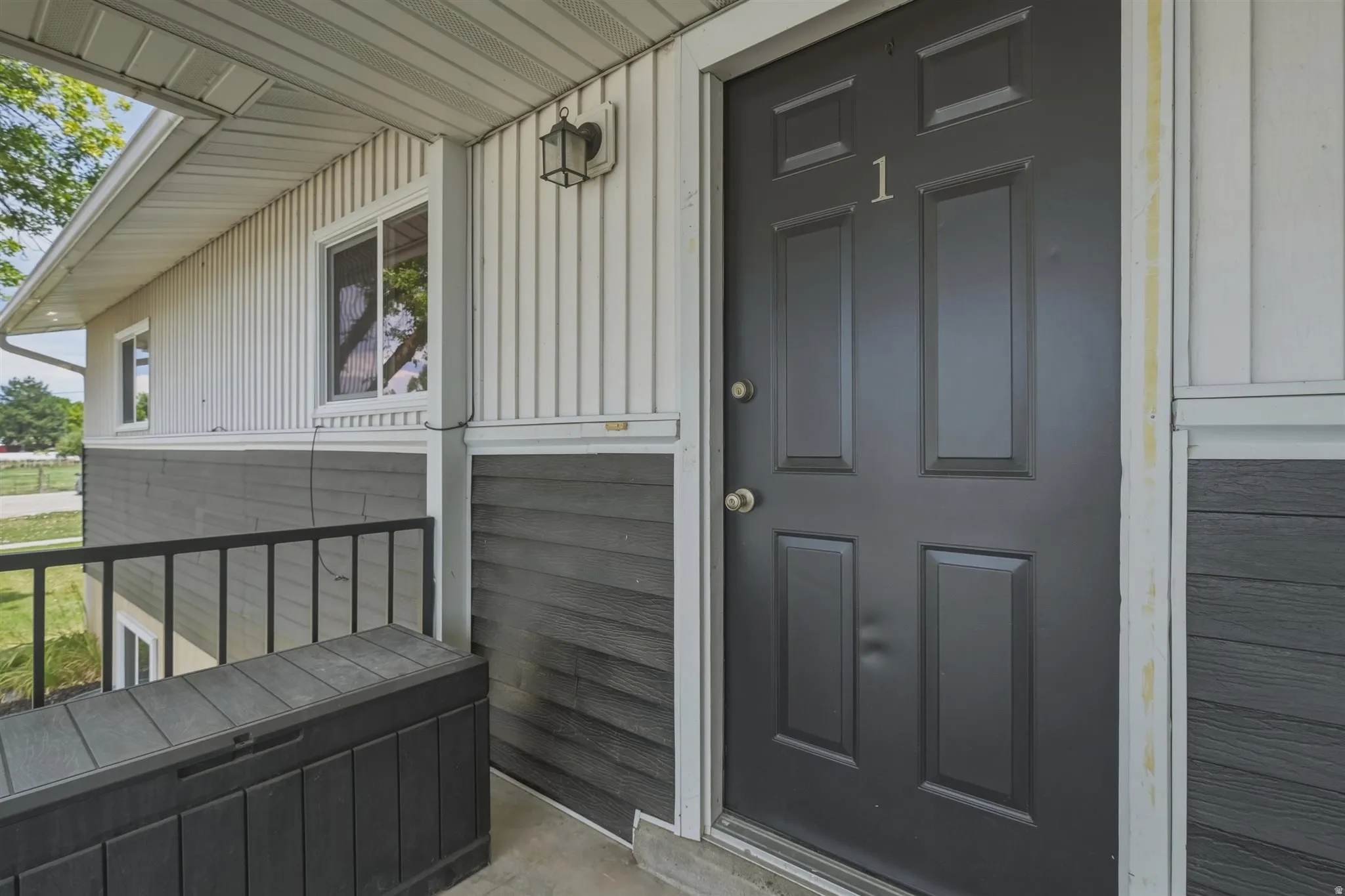 Entryway featuring a paneled door, exterior wall lantern, and a two-tone facade with vertical and horizontal siding