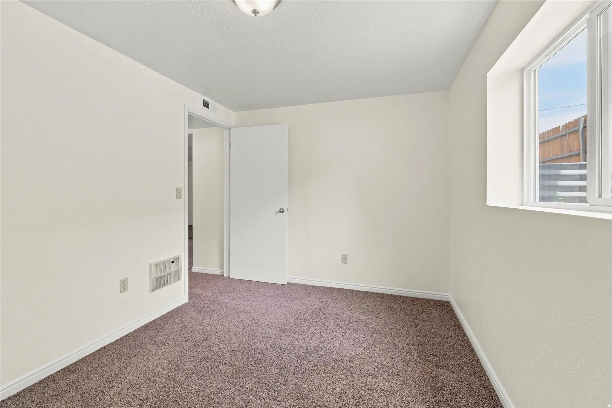 Room featuring light-colored walls and brown carpet flooring