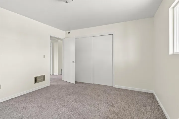 Carpeted room featuring a double-door closet, a single window, and neutral wall tones
