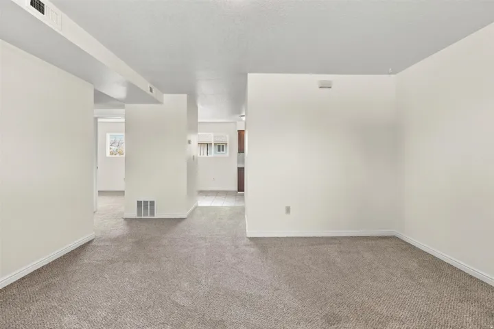 Carpeted room with light neutral wall paint and white baseboards