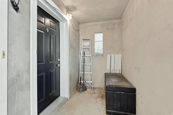 Black paneled entry door with white trim, featuring a number "4" and contemporary hardware