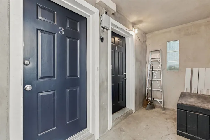 Entryway featuring a paneled door with silver-tone hardware, a corresponding paneled door, and concrete flooring