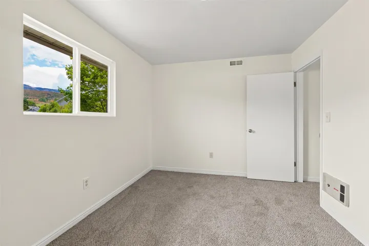 Room featuring light grey carpeting, white walls, and a white-framed window