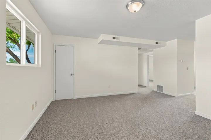 Spacious room featuring neutral carpeting and light-toned walls