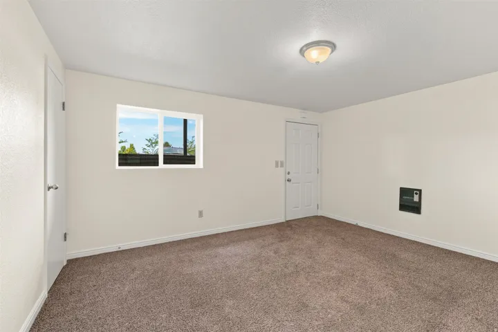 Carpeted room featuring a white paneled door, a horizontal window, and an overhead dome light fixture