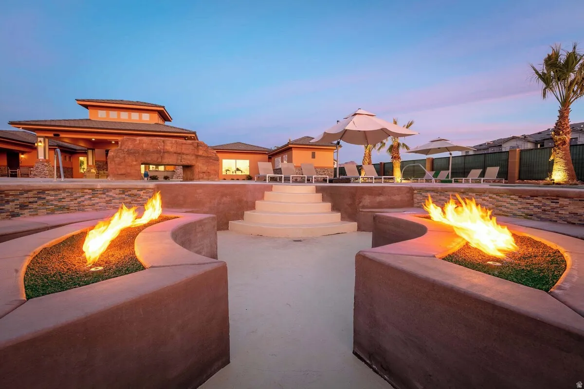 Outdoor entertainment area featuring two integrated curved fire features with decorative landscaping
