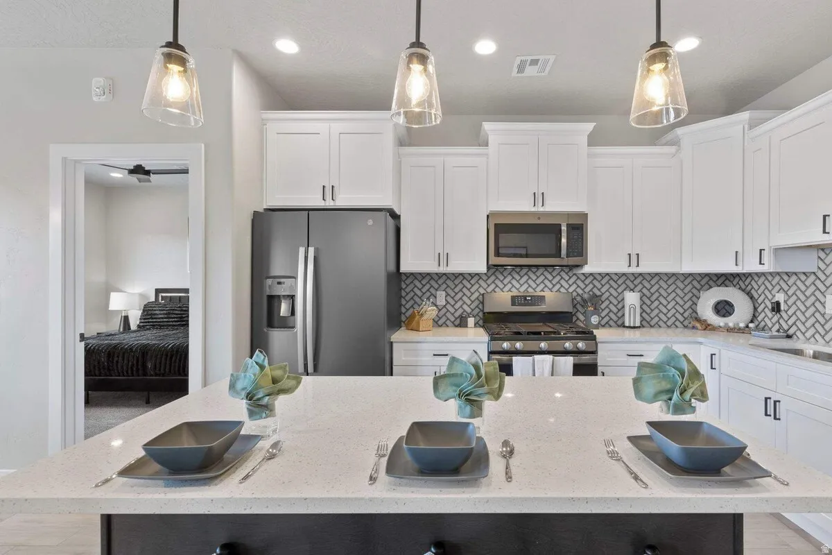 Kitchen island with a light-toned countertop, complemented by three pendant lights