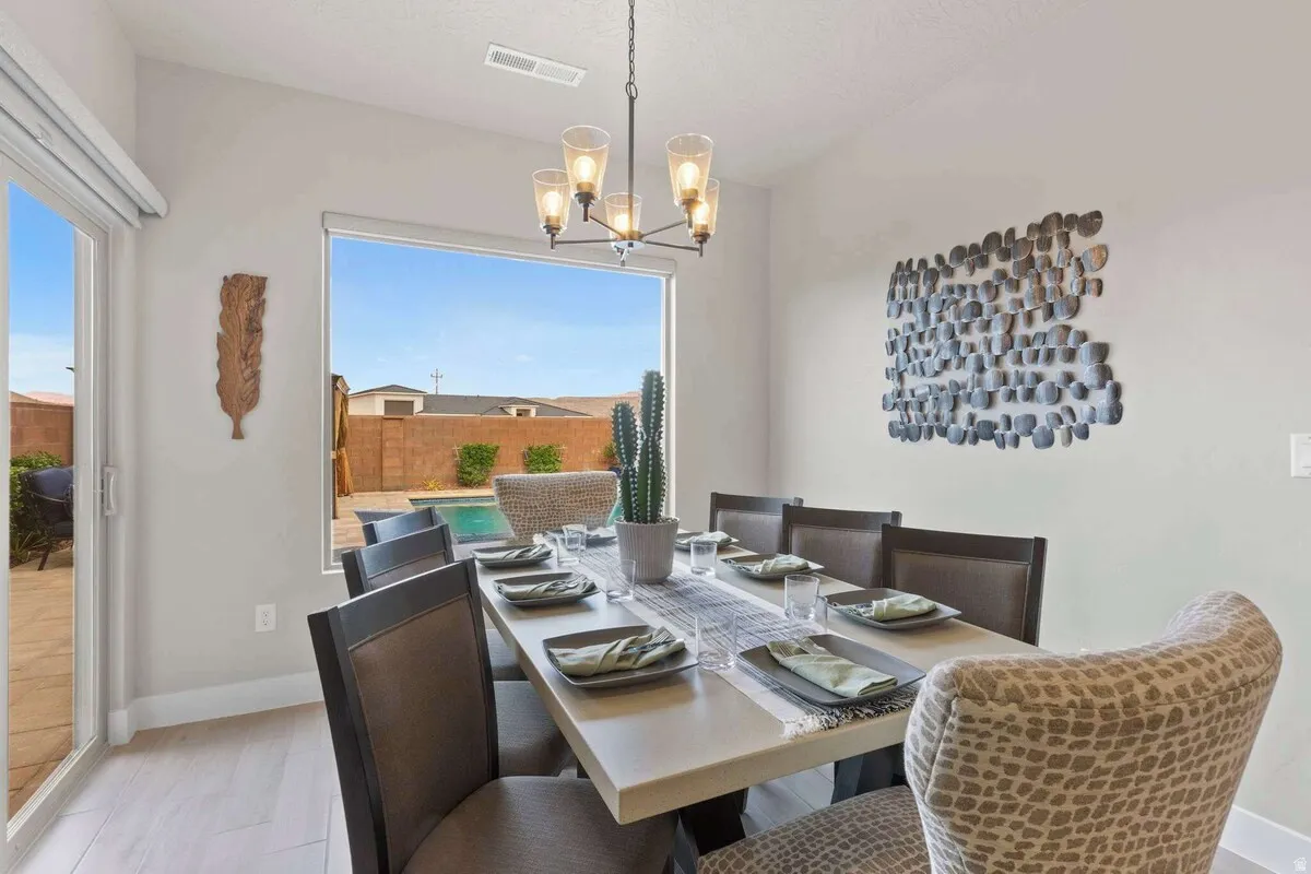 Dining area featuring light wood-finish flooring and a contemporary chandelier